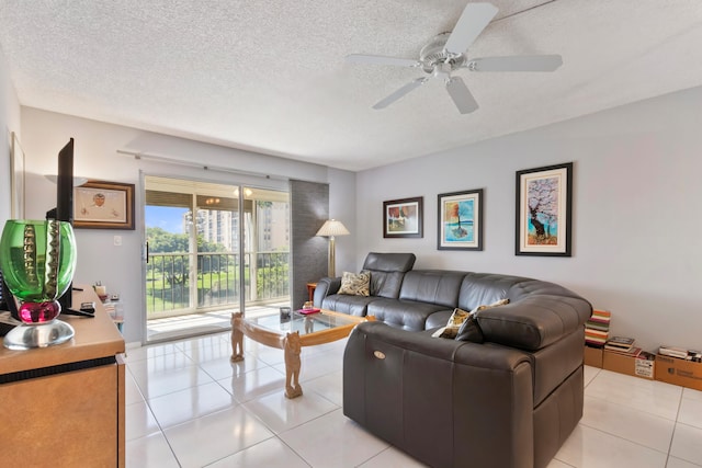 living area with a textured ceiling, ceiling fan, and light tile patterned floors