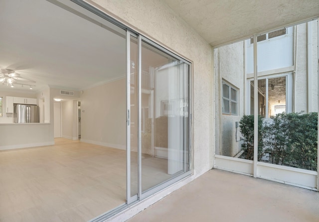 unfurnished sunroom featuring ceiling fan