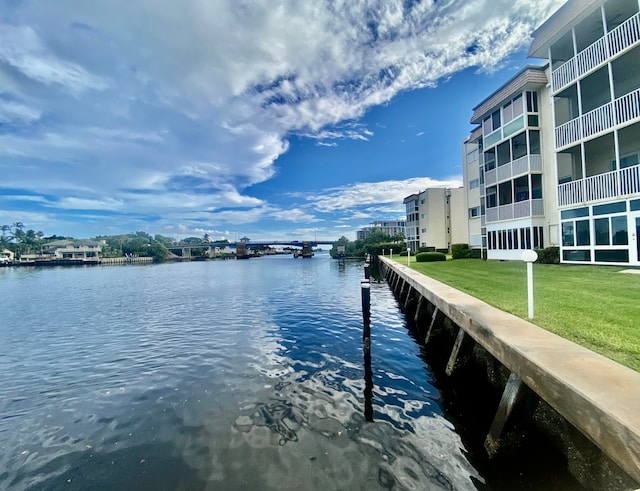 view of dock with a water view and a yard