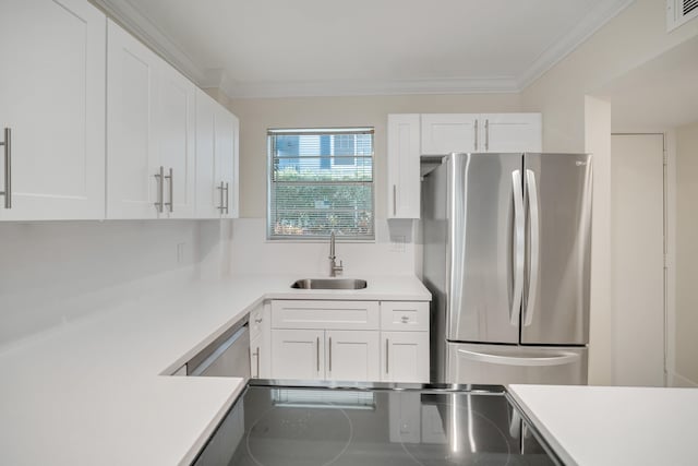 kitchen featuring stainless steel refrigerator, crown molding, sink, and white cabinets