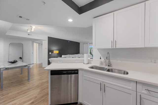 kitchen with white cabinets, a raised ceiling, sink, stainless steel dishwasher, and light hardwood / wood-style floors