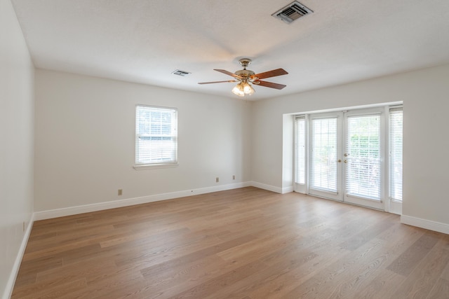 spare room featuring french doors, light wood-type flooring, and ceiling fan