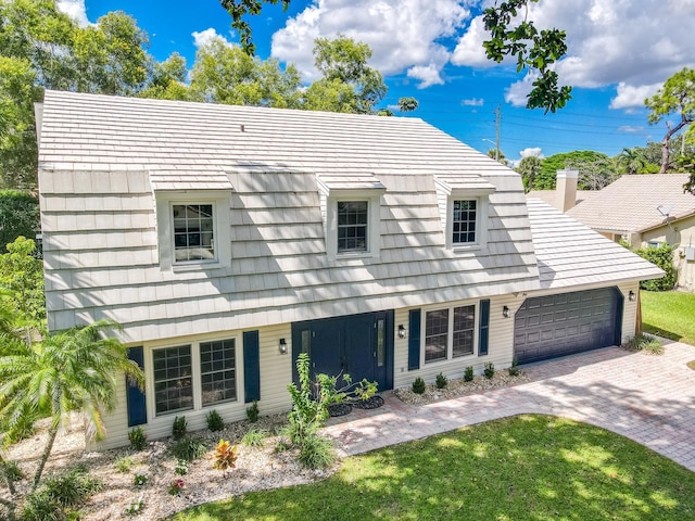 view of front of home with a garage and a front lawn