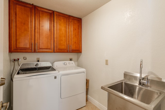 washroom with washer and clothes dryer, cabinets, sink, and a textured ceiling