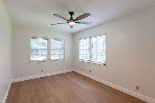 unfurnished room featuring ceiling fan, a textured ceiling, light wood-type flooring, and a wealth of natural light