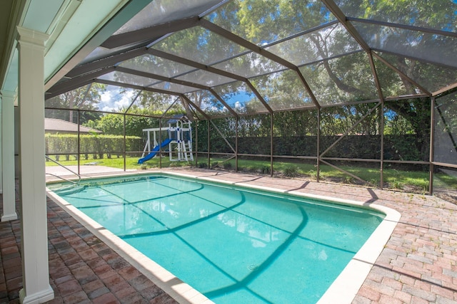 view of pool with glass enclosure and a patio area