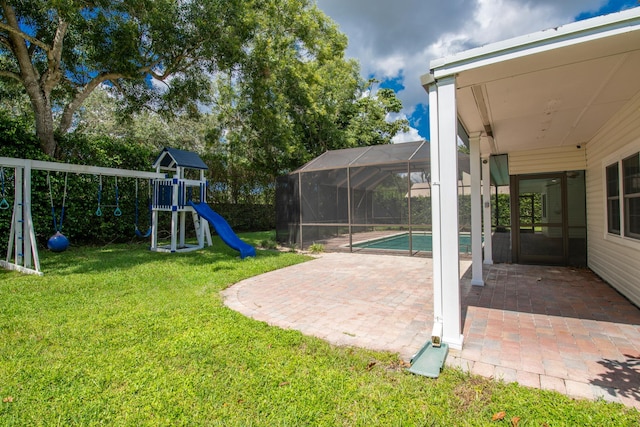 view of yard with a playground, glass enclosure, and a patio area