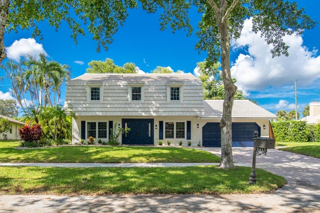 view of front of property featuring a garage and a front lawn