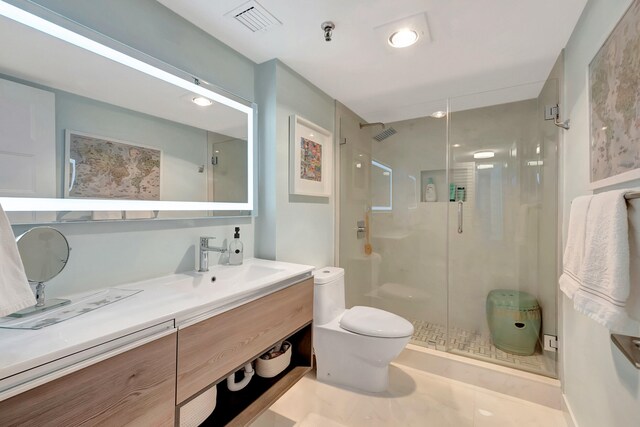 bathroom with vanity, toilet, and a shower with door