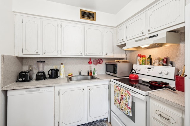 kitchen featuring sink, white appliances, and white cabinetry