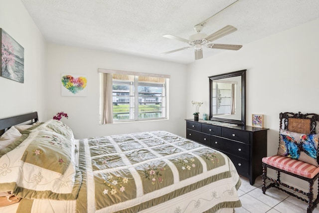 bedroom featuring ceiling fan, a textured ceiling, and light tile patterned flooring