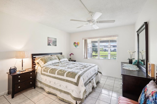 tiled bedroom with ceiling fan and a textured ceiling