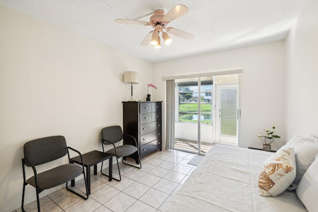 tiled bedroom with ceiling fan and a textured ceiling