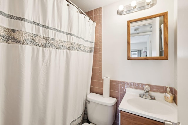 bathroom featuring tile walls, walk in shower, vanity, and toilet