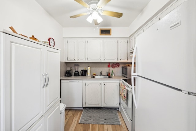 kitchen featuring light wood-type flooring, stainless steel appliances, white cabinets, tasteful backsplash, and sink