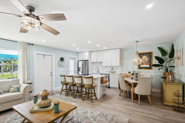 living room with sink, ceiling fan, and light hardwood / wood-style flooring