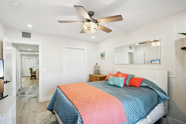 bedroom featuring ceiling fan, a closet, and light hardwood / wood-style flooring