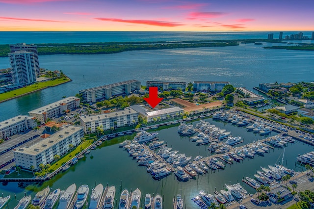 aerial view at dusk featuring a water view