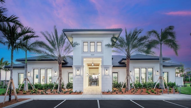 view of front of home with stucco siding and uncovered parking