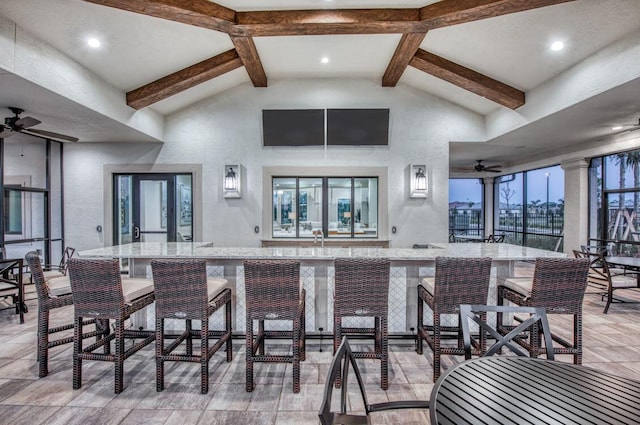 dining space with beamed ceiling, high vaulted ceiling, and ceiling fan