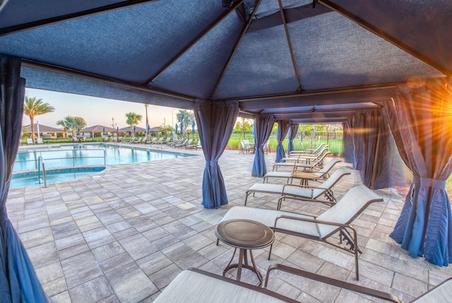 view of patio featuring a gazebo and a community pool