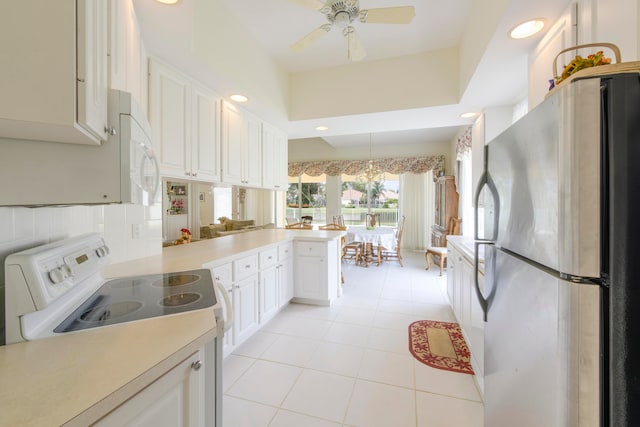 kitchen featuring kitchen peninsula, white cabinets, ceiling fan with notable chandelier, and white appliances