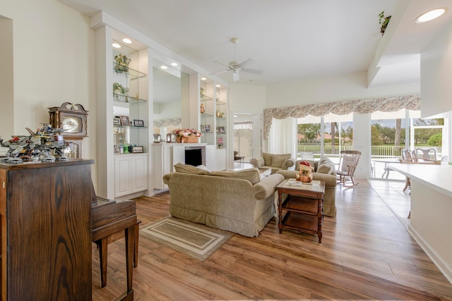 living room with light wood-type flooring and ceiling fan