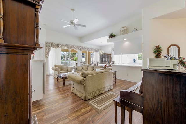 living room with light hardwood / wood-style floors and ceiling fan with notable chandelier