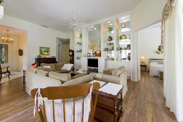 living room featuring wood-type flooring and ceiling fan with notable chandelier