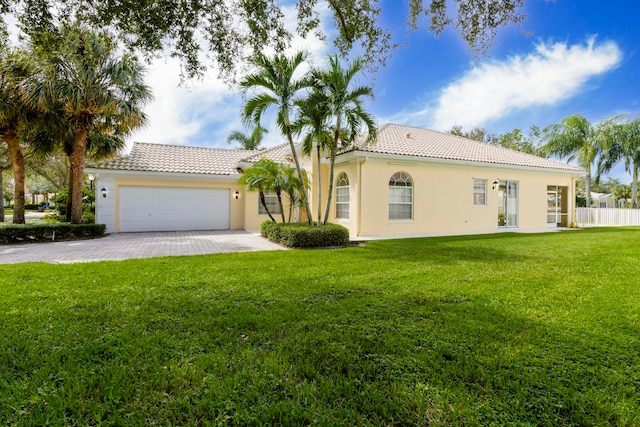 mediterranean / spanish-style house featuring a garage and a front lawn