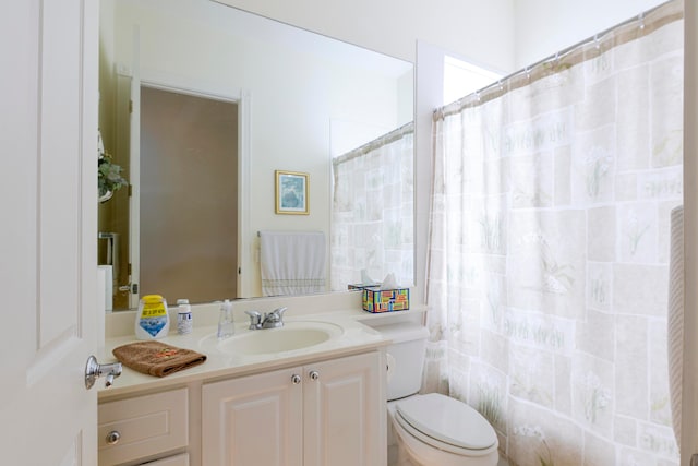 bathroom with vanity, toilet, and walk in shower