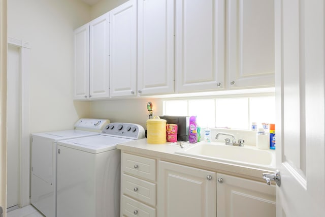 washroom featuring sink, cabinets, and washer and clothes dryer