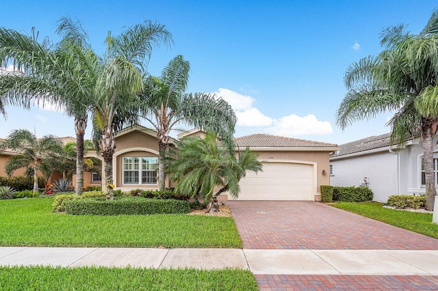 mediterranean / spanish-style home featuring a garage and a front lawn