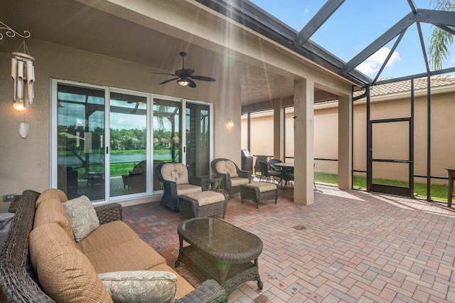 view of patio with an outdoor hangout area, glass enclosure, and ceiling fan