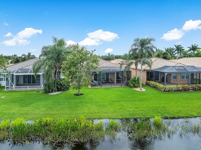 back of property featuring glass enclosure, a water view, a yard, and a patio area