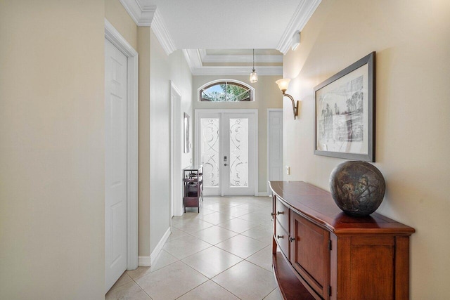 tiled entrance foyer featuring a tray ceiling and crown molding