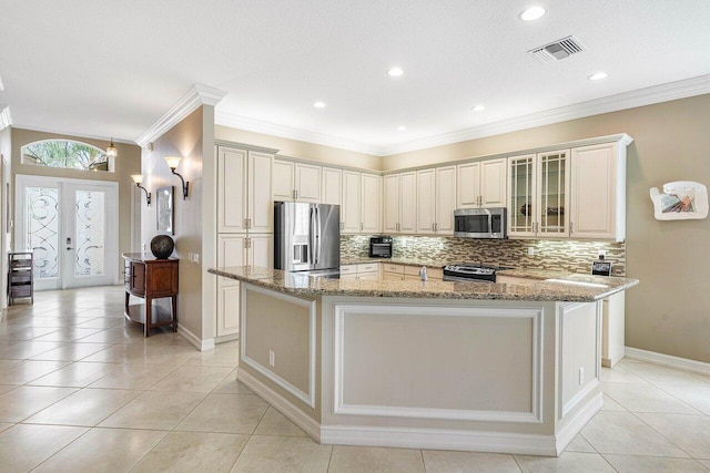 kitchen featuring appliances with stainless steel finishes, a center island with sink, french doors, and light stone counters