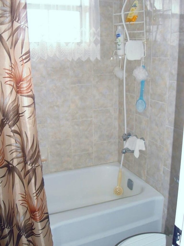 bathroom with toilet and shower / bathtub combination with curtain