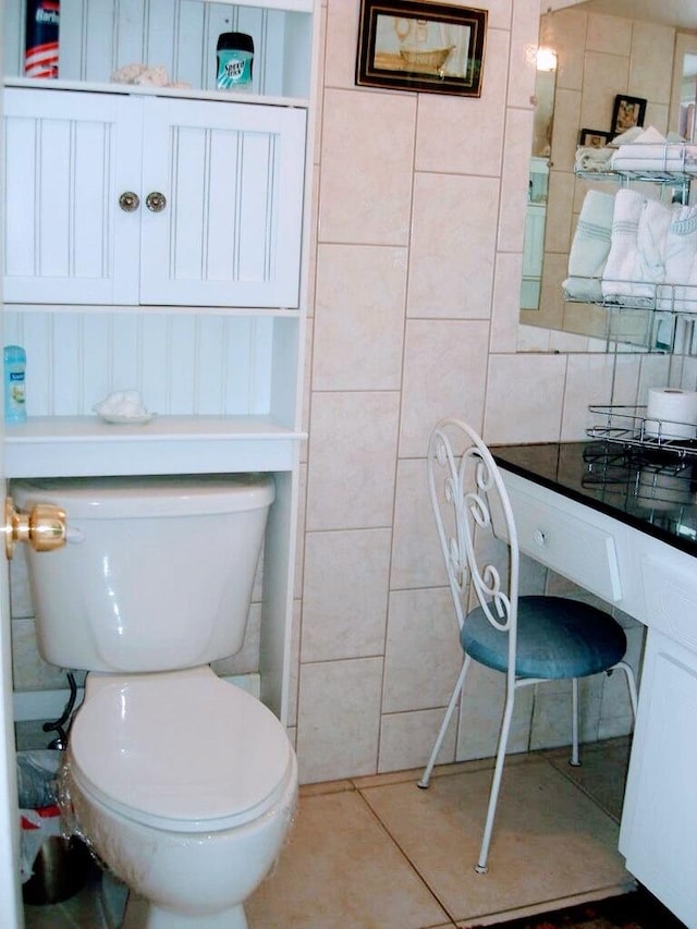 bathroom featuring toilet, tile walls, and tile patterned flooring