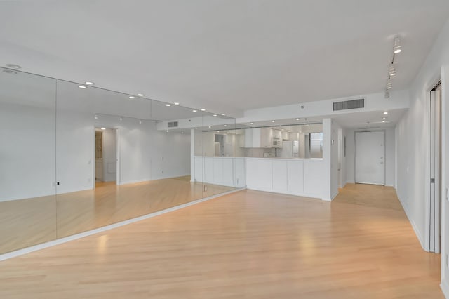 empty room with basketball court and light hardwood / wood-style flooring