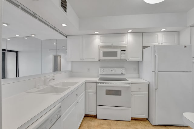 kitchen featuring sink, white appliances, and white cabinetry