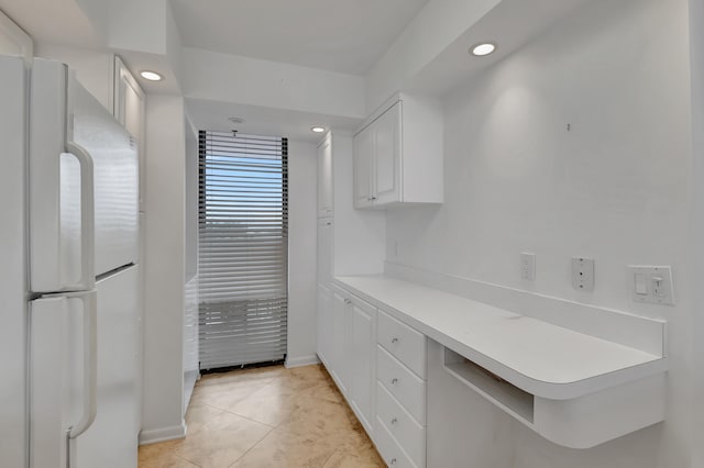 kitchen with light tile patterned floors, white cabinets, and white fridge