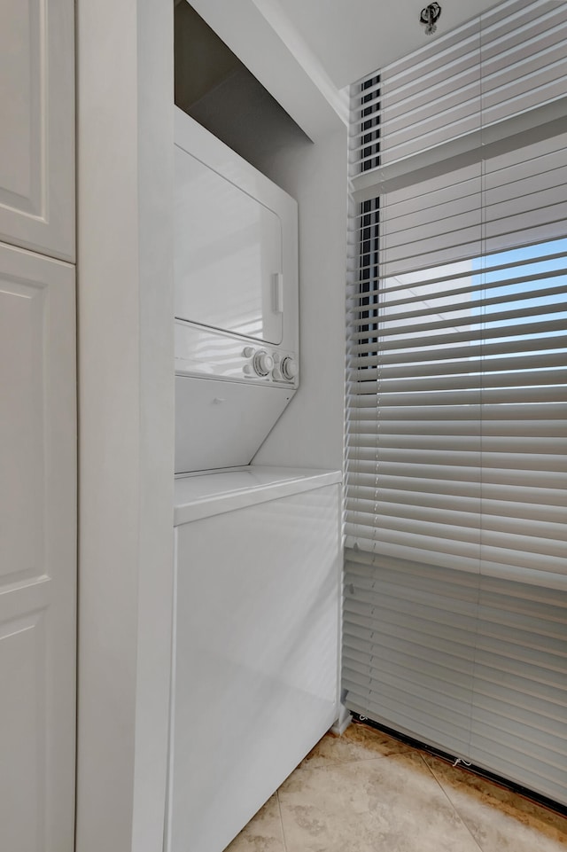 clothes washing area with stacked washer and clothes dryer