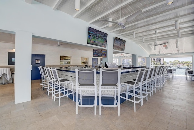 dining room with high vaulted ceiling, ceiling fan, beam ceiling, and plenty of natural light