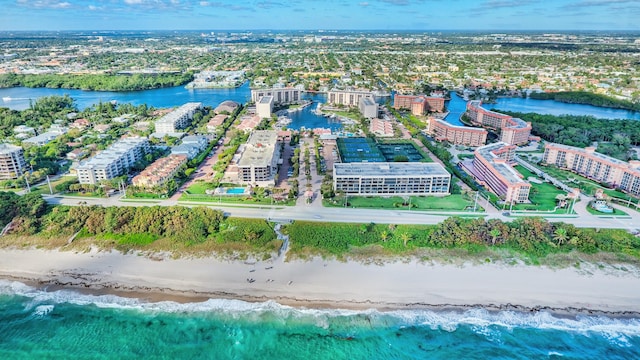 birds eye view of property with a water view, a view of city, and a beach view