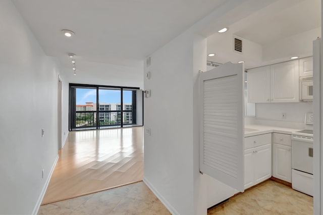 kitchen with range with electric stovetop, white cabinetry, and light hardwood / wood-style floors