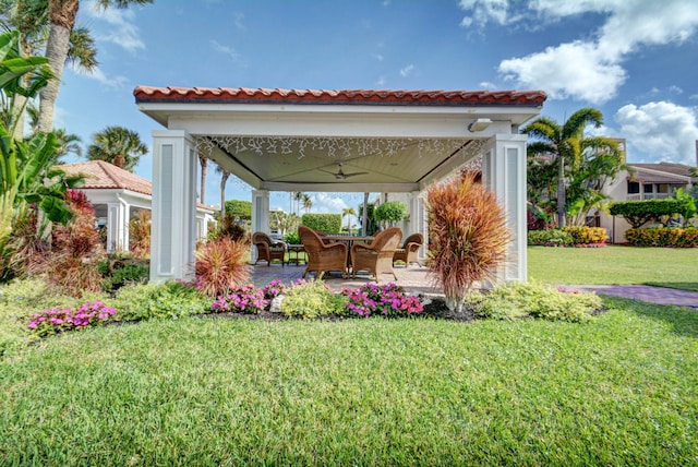 view of yard featuring a patio area and ceiling fan