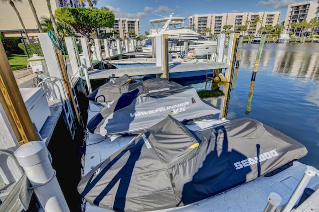 view of dock featuring a water view and a view of city
