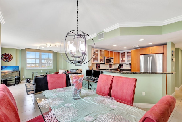 tiled dining room featuring a notable chandelier, sink, and crown molding