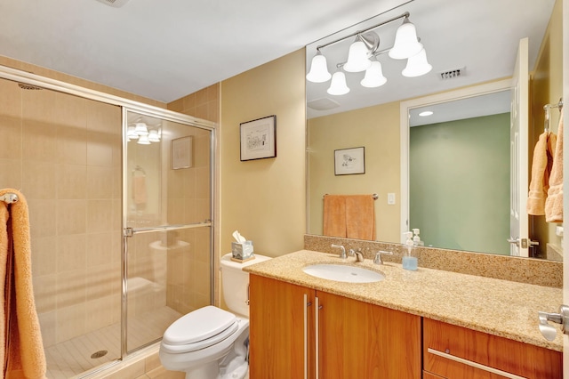 bathroom featuring vanity, toilet, and an enclosed shower